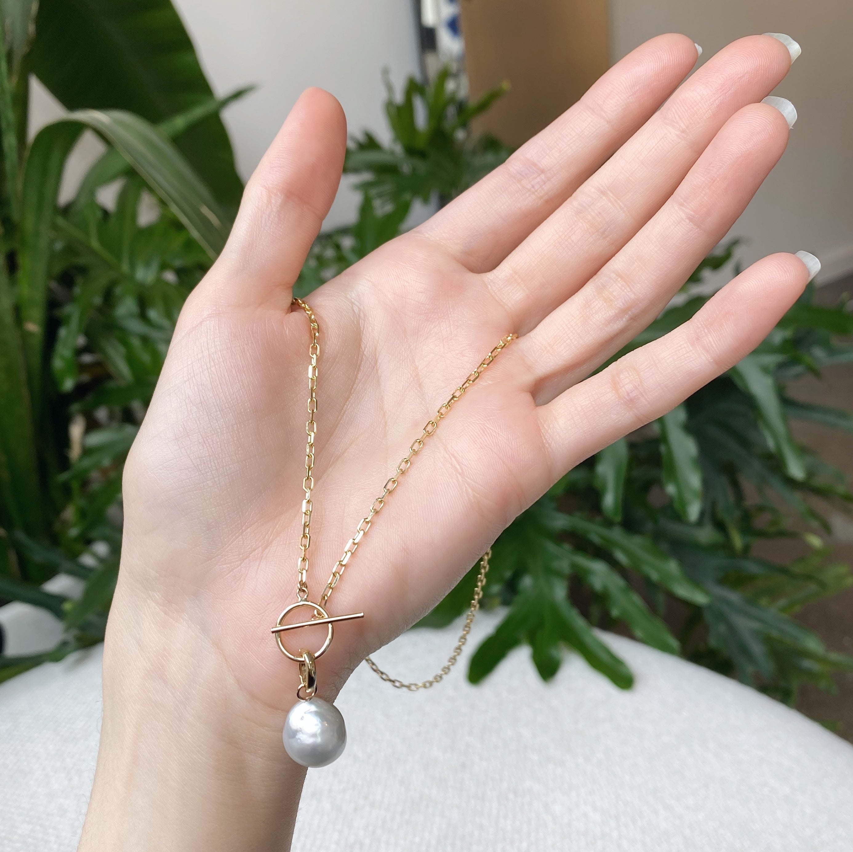 gold toggle with pearl pendant in hand