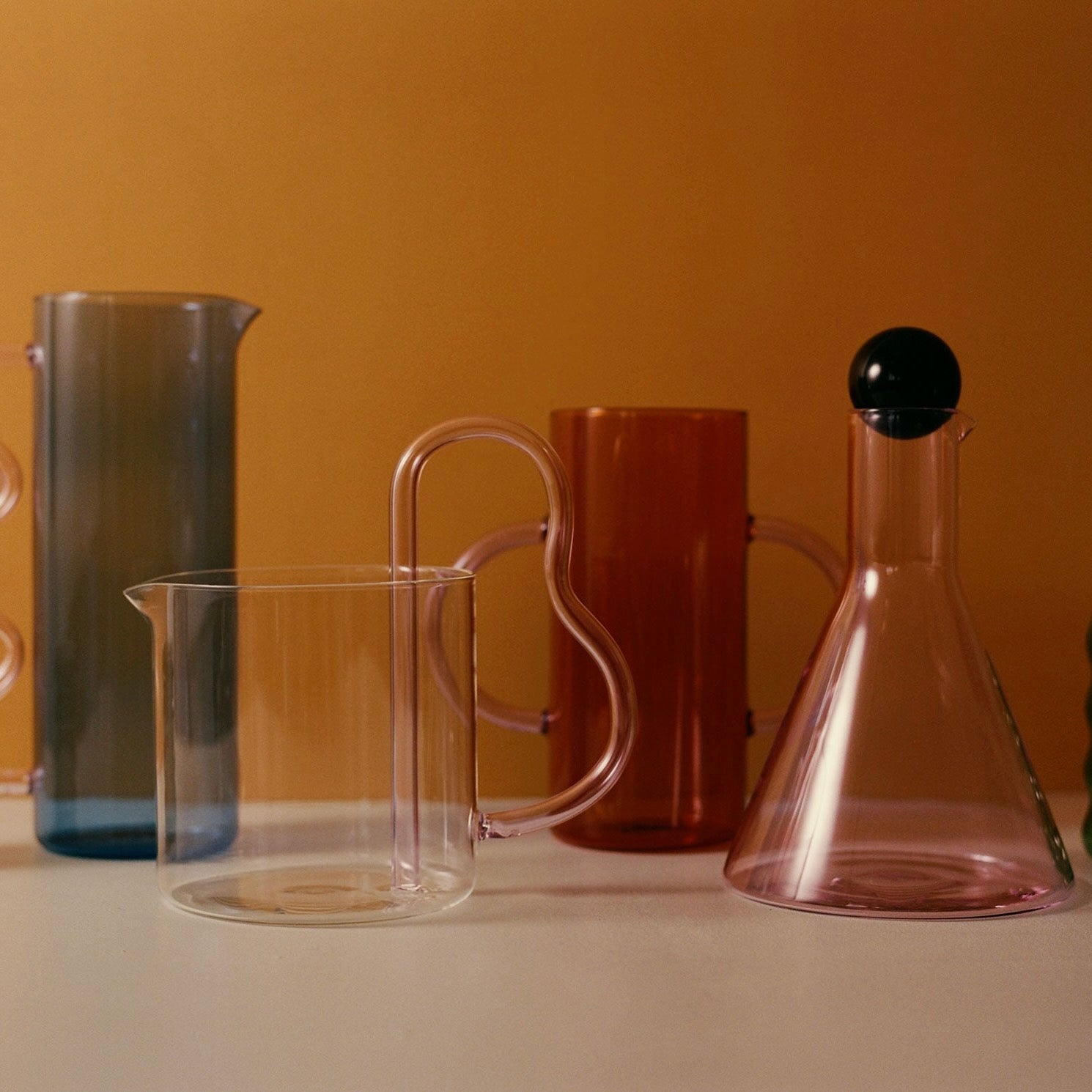 glass pitchers on organge background
