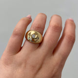 gold bombe ring with round diamond on hand with white background