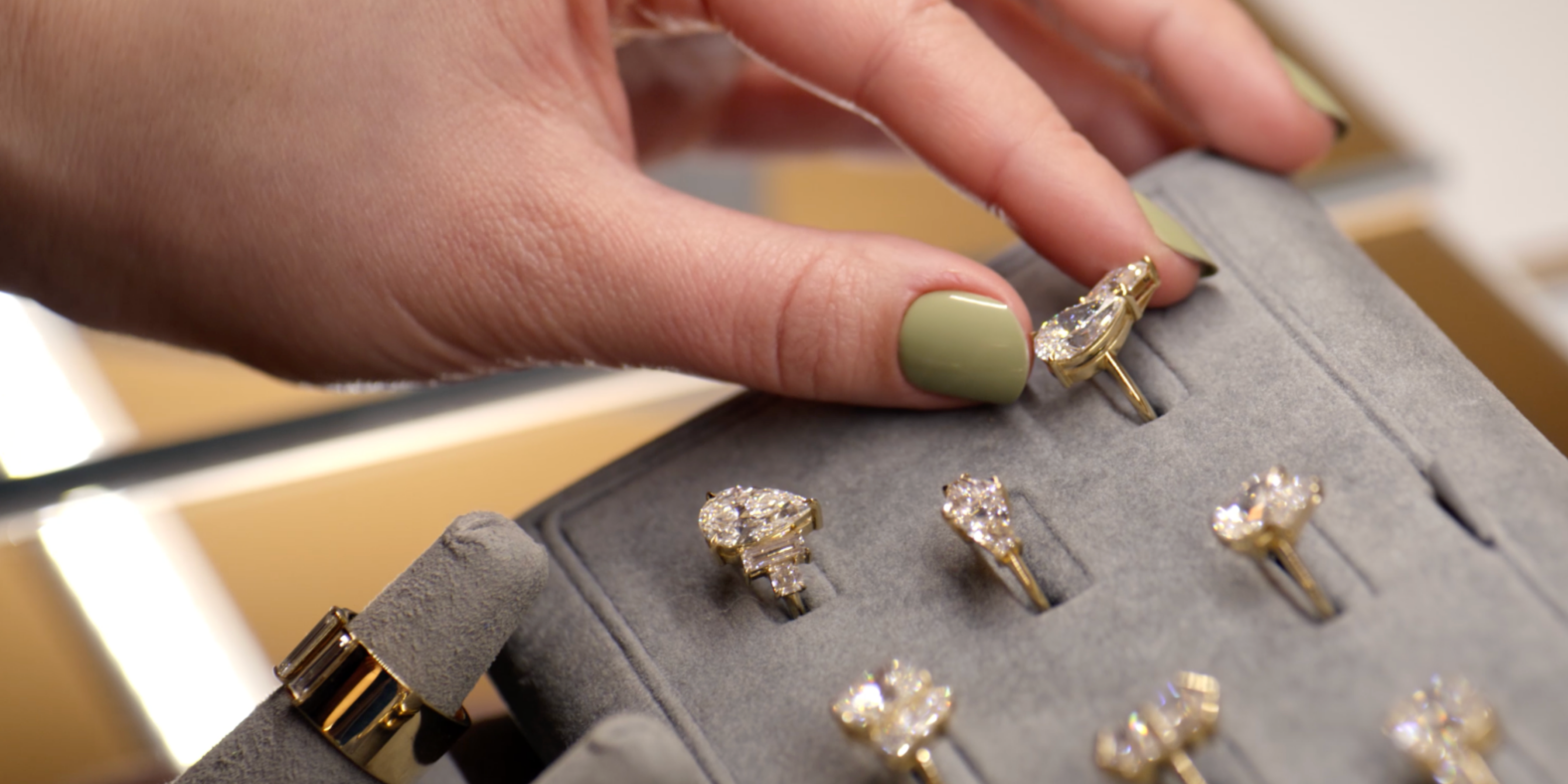 Hand selecting diamond rings from a display case