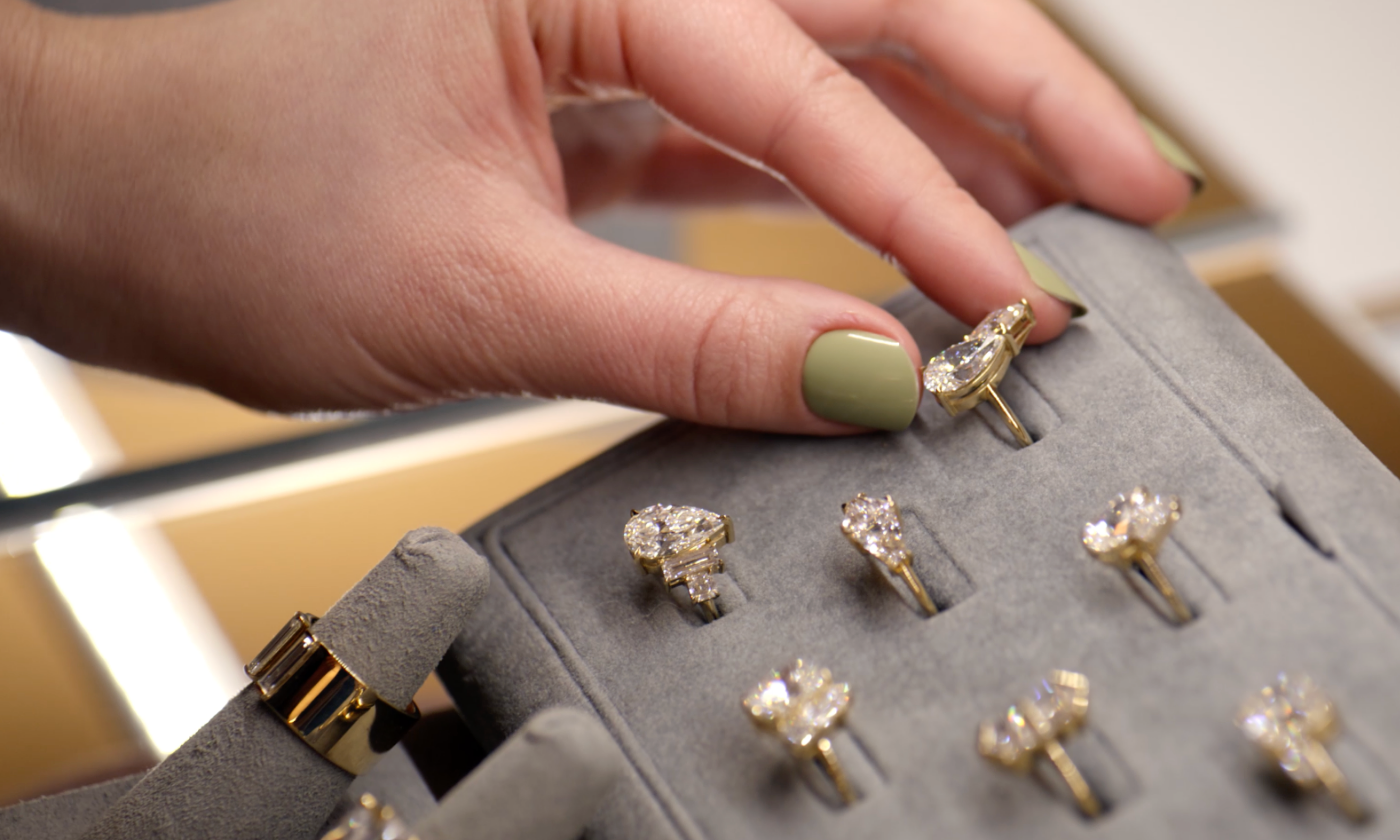 Hand selecting diamond rings from a display case