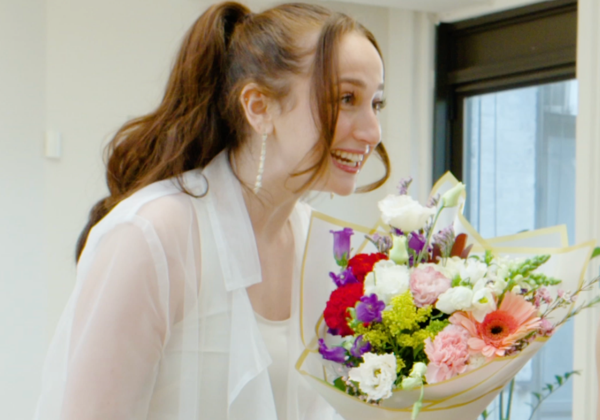 Woman holding a bouquet of flowers indoors