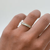 Hand wearing a diamond ring on a plain background