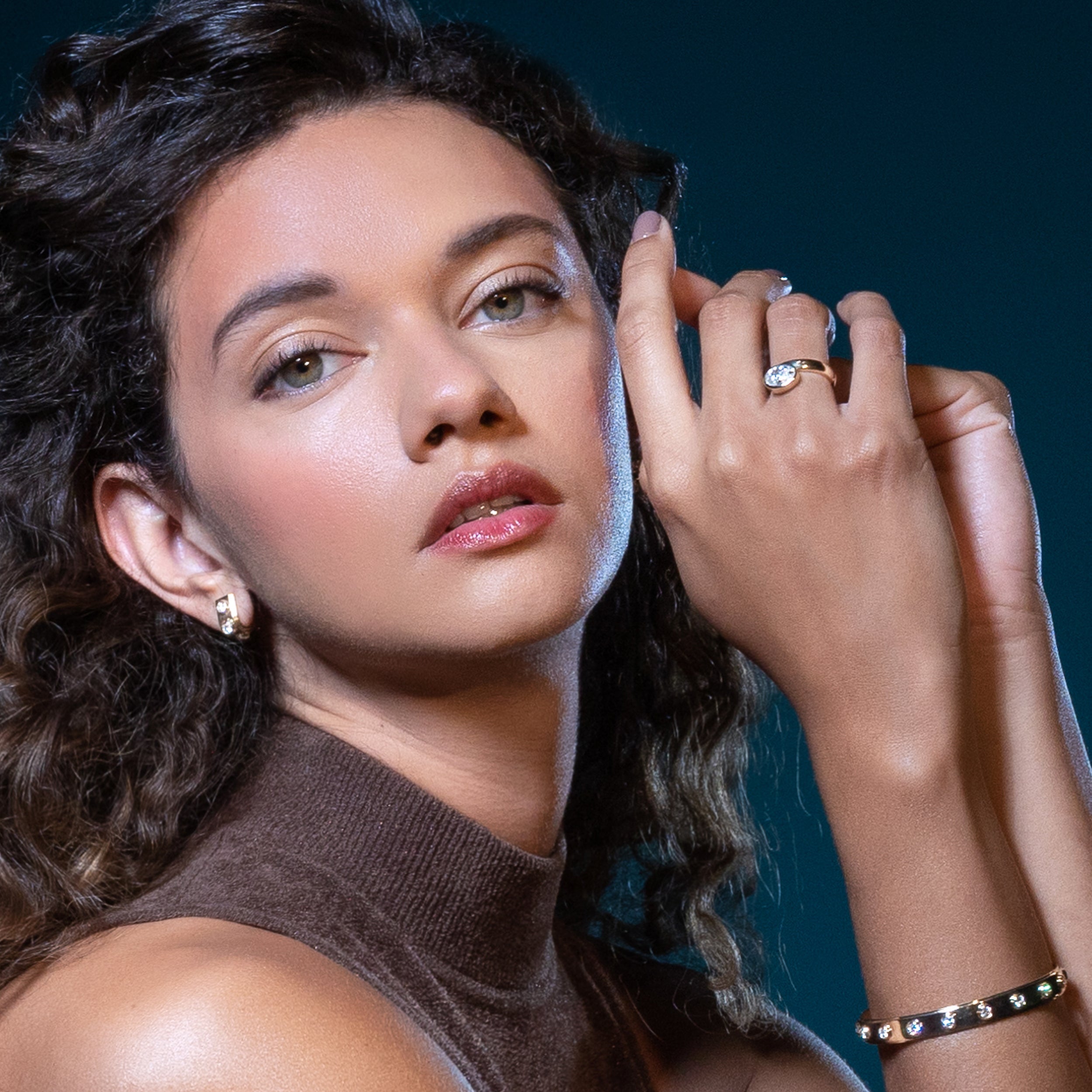 Ring and bracelet in 14k gold and diamonds by Shahla Karimi on model on dark background