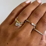 Rings in 14k gold and diamonds by Shahla Karimi on hand on light background