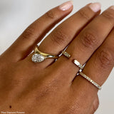 Rings in 14k gold and diamonds by Shahla Karimi on hand on light background