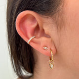 Pear Earring Charms by Shahla Karimi on ear on light background