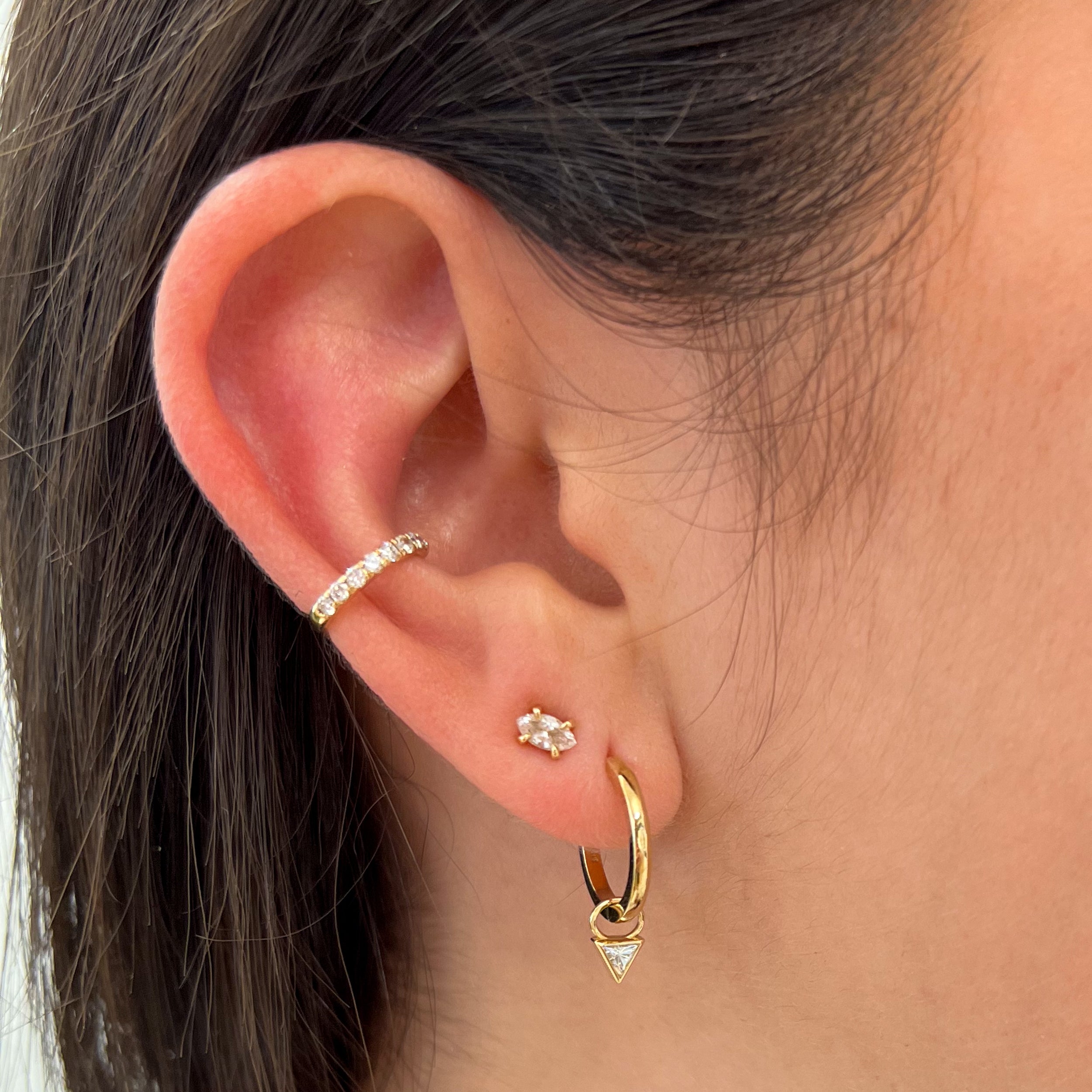 Triangle Earring Charms by Shahla Karimi on ear on light background