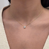 Close-up of Shahla Karimi pendant on person in yellow gold round-cut diamond