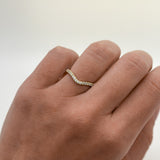 Close-up of a hand wearing a diamond ring on a light background