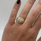 Gold ring with a diamond on a hand against a neutral background