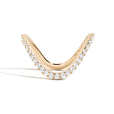 A curved yellow gold ring with a pave of diamonds set into the band by Shahla Karimi on white background
