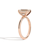 rose gold ring with a champagne emerald-cut diamond on a white background