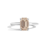silver ring with a champagne emerald-cut diamond on a white background