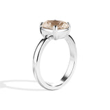 Silver ring with a brown gemstone on a white background