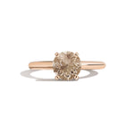 Rose gold ring with a brown gemstone on a white background