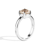 Silver ring with a brown gemstone on a white background