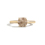 Gold ring with a brown gemstone on a white background