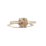 Gold ring with a brown gemstone on a white background