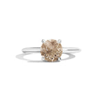 Diamond ring with a brown gemstone on a white background