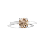 Diamond ring with a brown gemstone on a white background