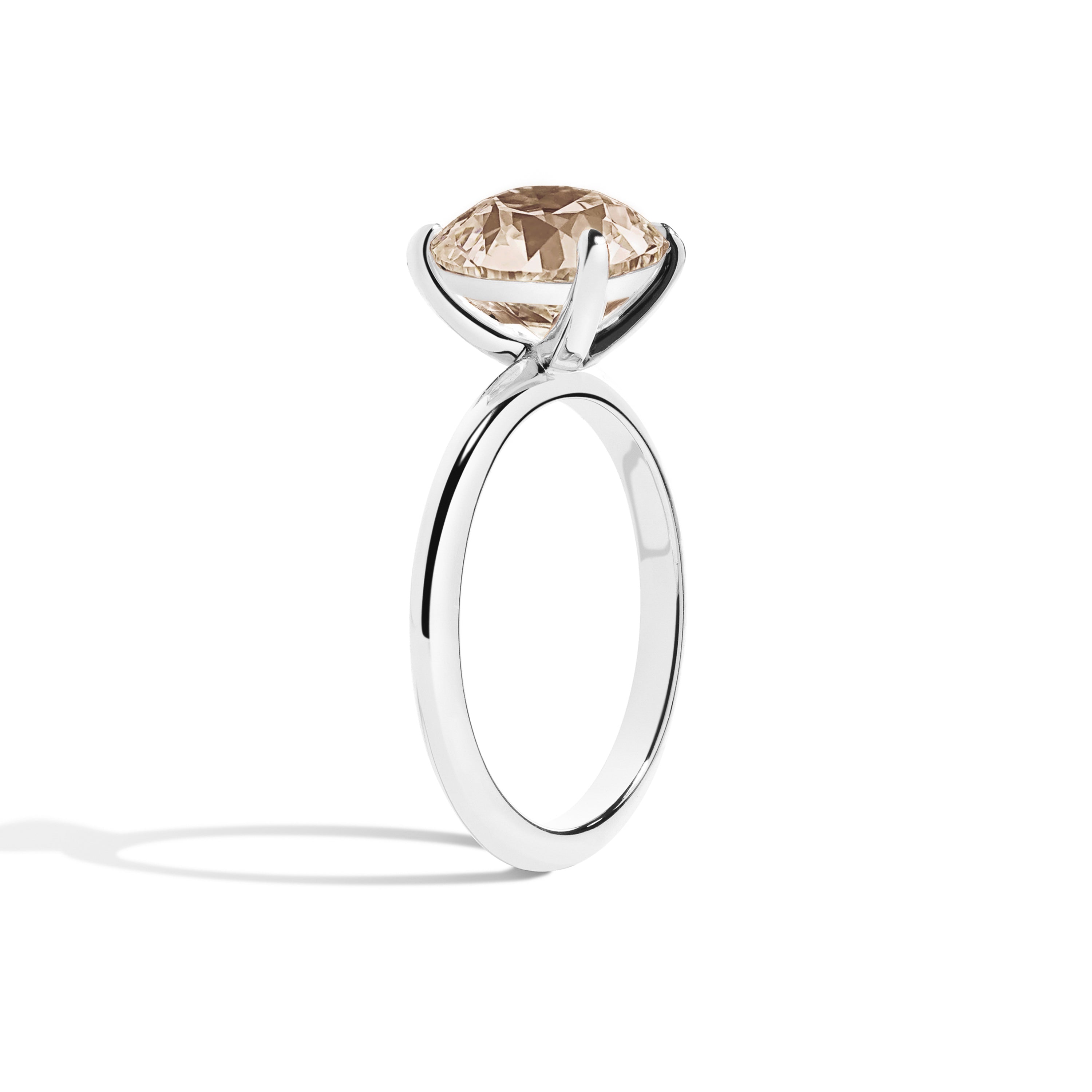 Silver ring with a brown gemstone on a white background