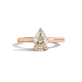 Gold ring with a pear-shaped diamond on a white background