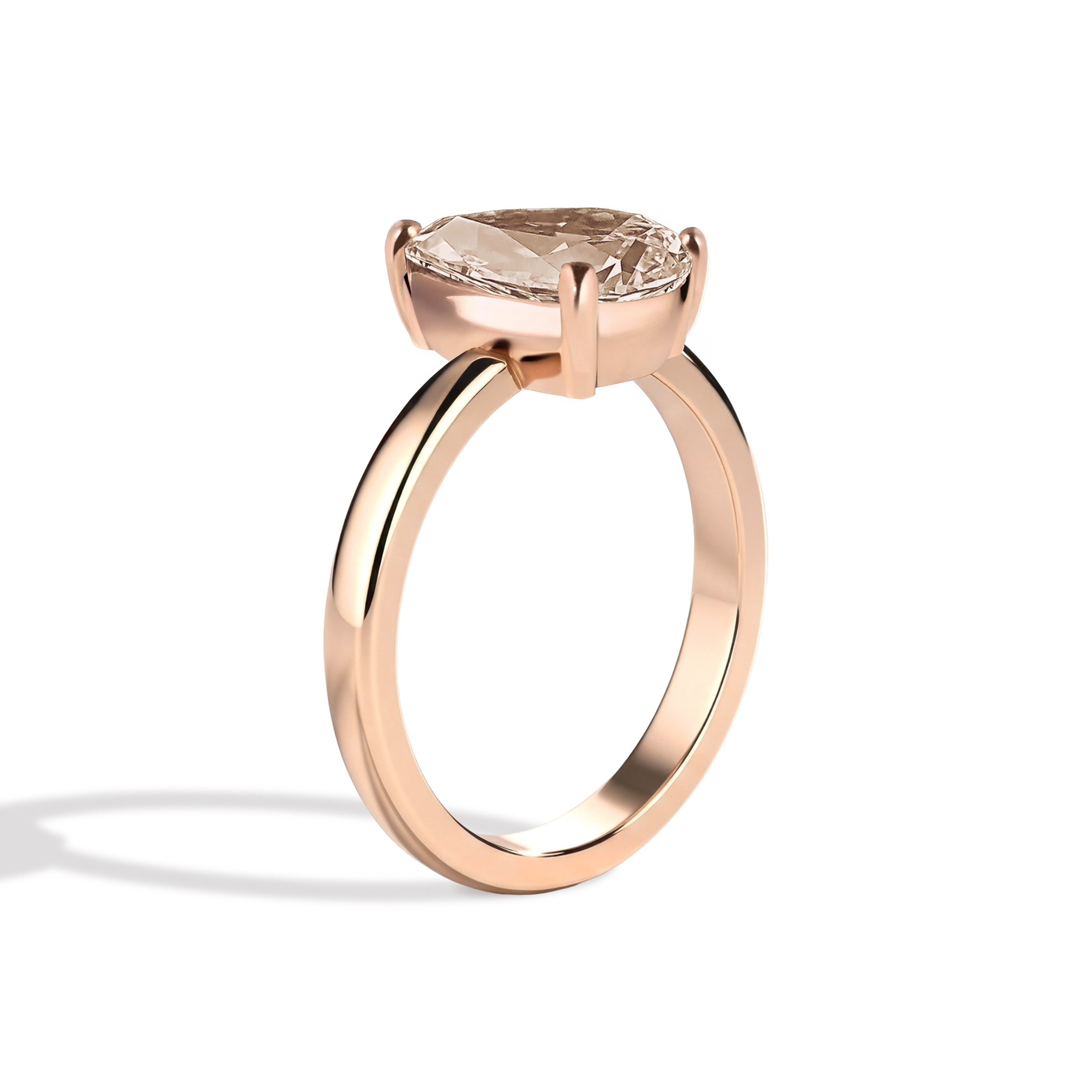 Rose gold ring with a pear-shaped diamond on a white background