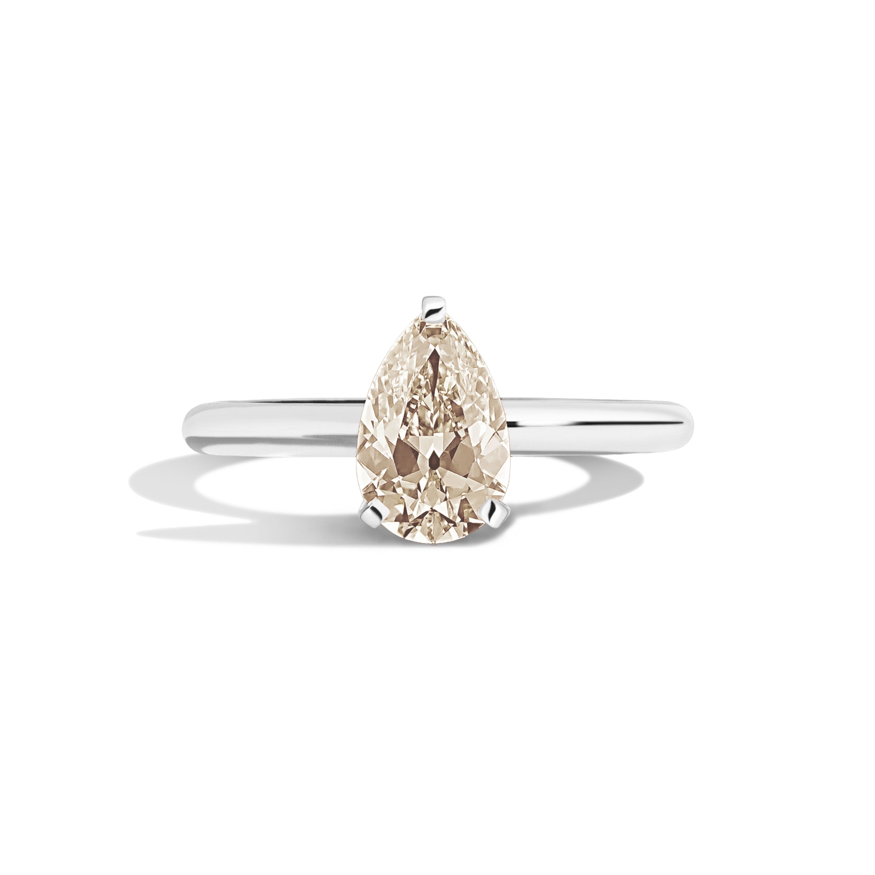 Gold ring with a pear-shaped diamond on a white background