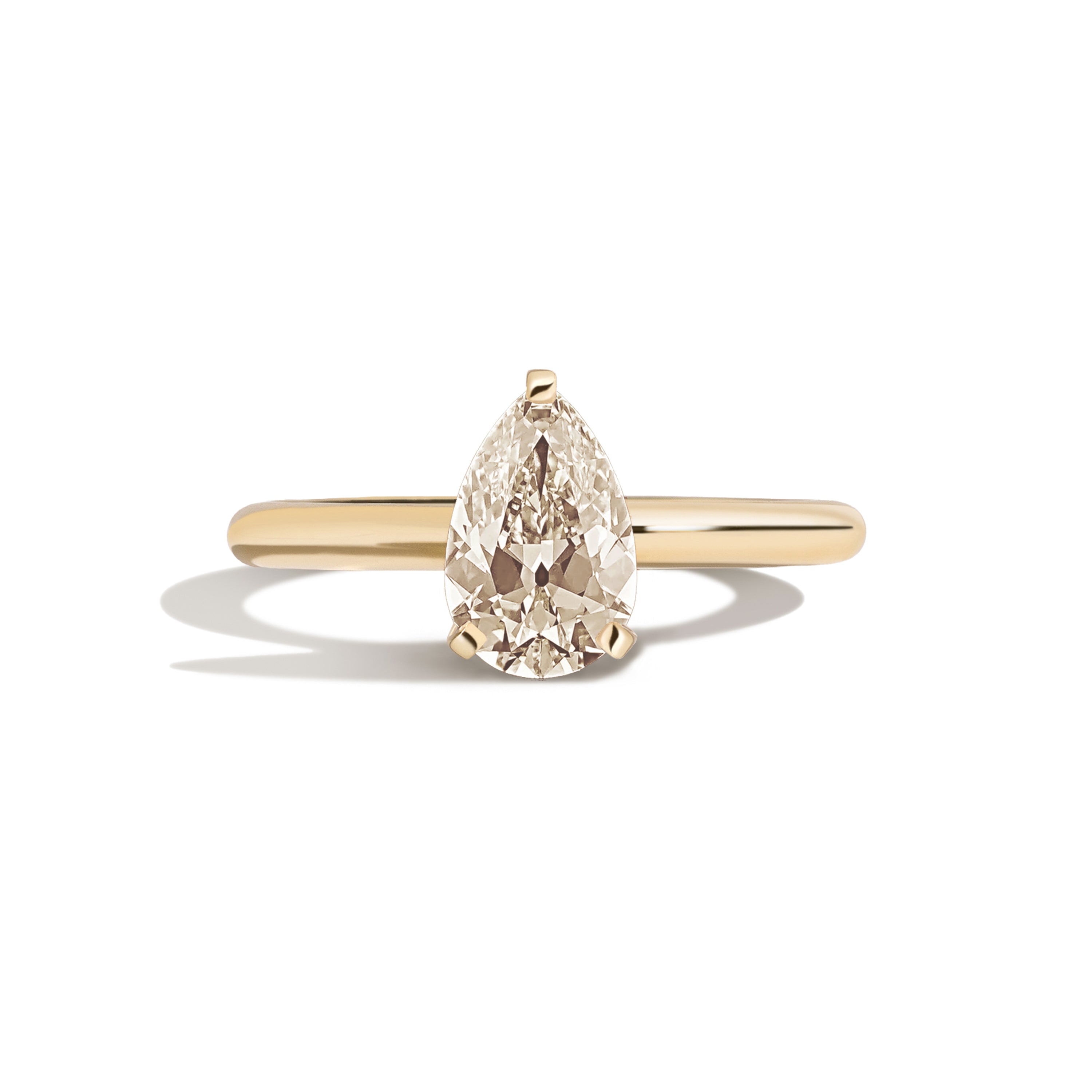 Gold ring with a pear-shaped diamond on a white background