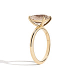 Gold ring with a pear-shaped diamond on a white background