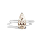 Gold ring with a pear-shaped diamond on a white background