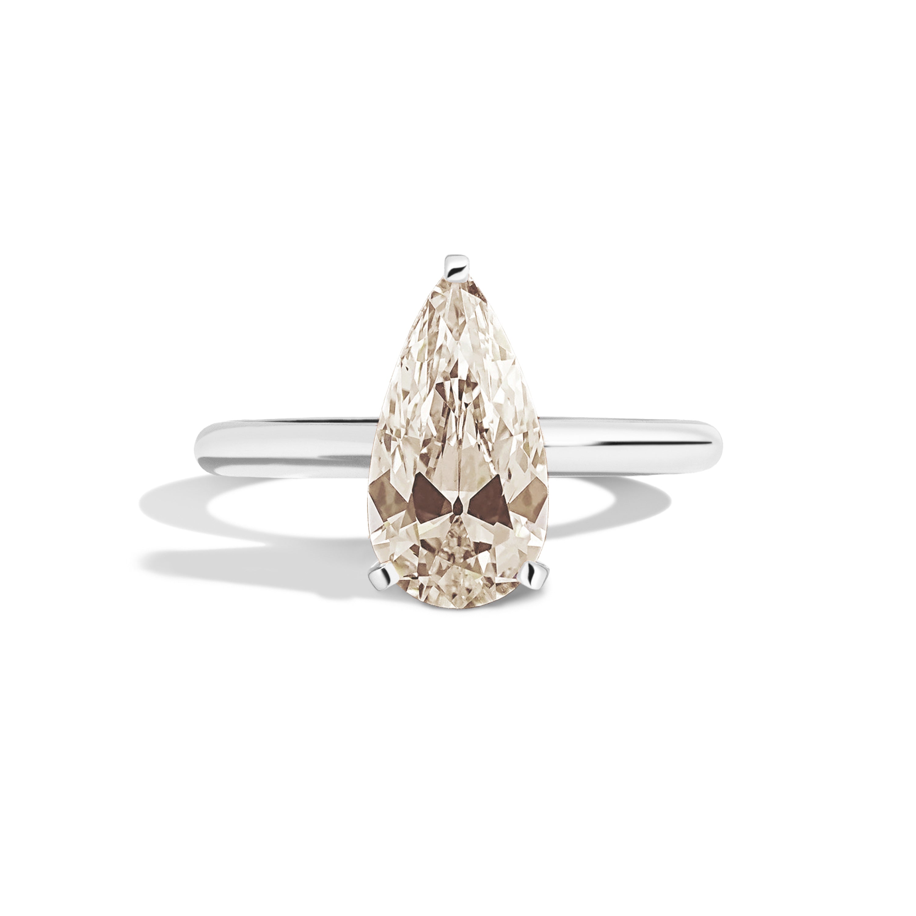 Gold ring with a pear-shaped diamond on a white background