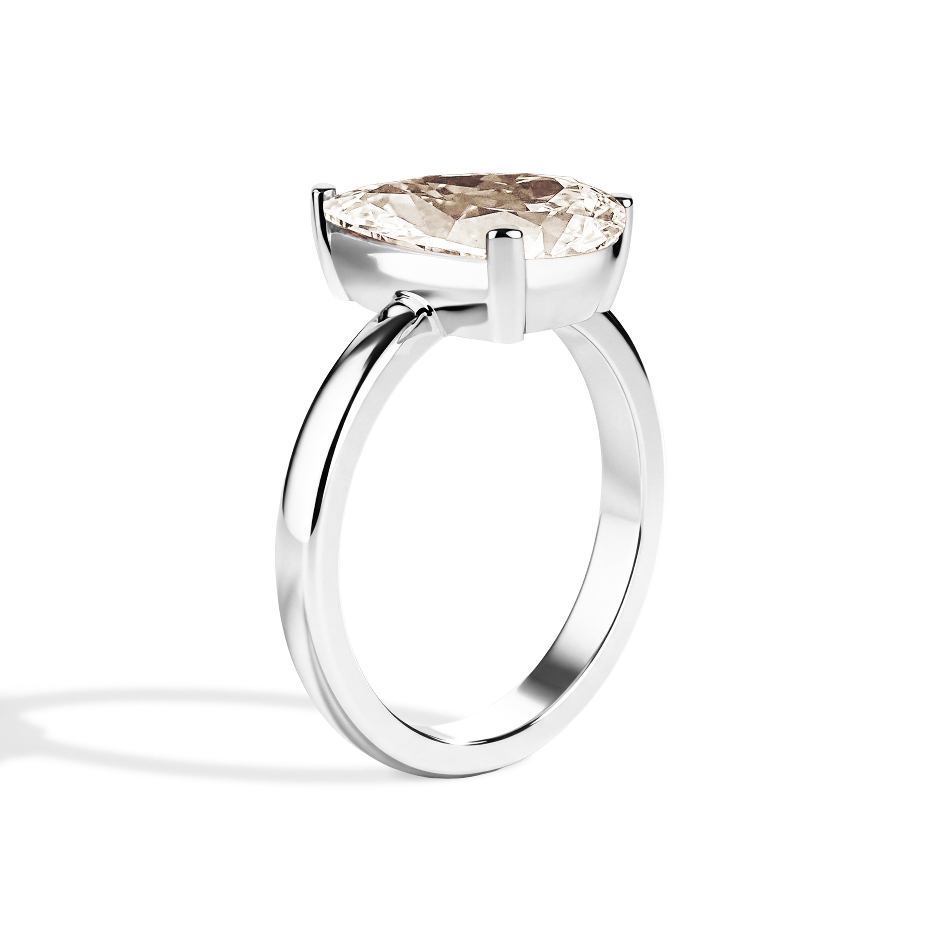Gold ring with a pear-shaped diamond on a white background