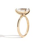 Gold ring with a pear-shaped diamond on a white background
