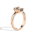 rose gold ring with a champagne emerald-cut diamond on a white background