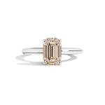 silver ring with a champagne emerald-cut diamond on a white background