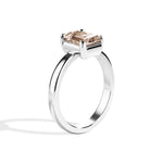 silver ring with a champagne emerald-cut diamond on a white background