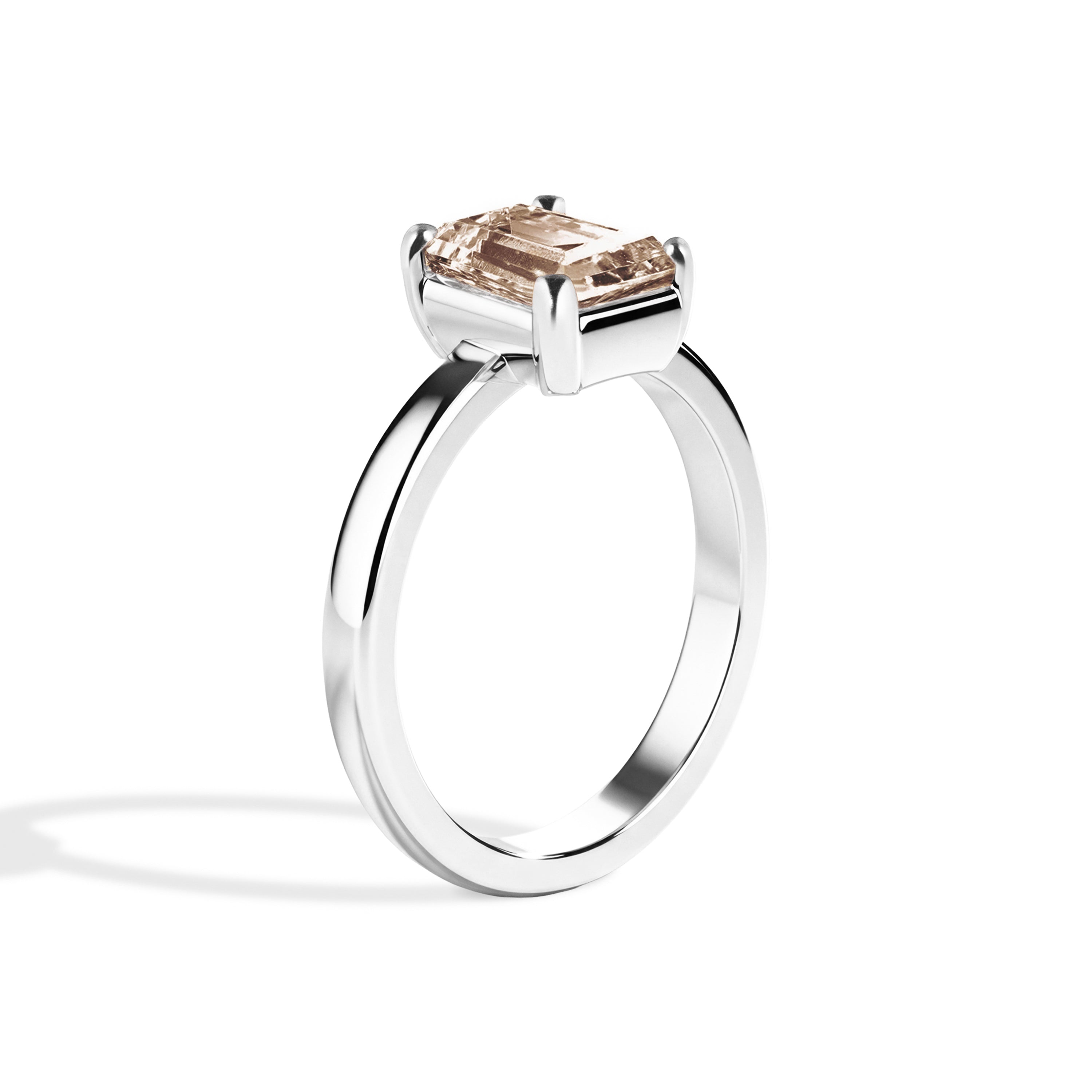 silver ring with a champagne emerald-cut diamond on a white background