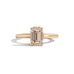 gold ring with a champagne emerald-cut diamond on a white background