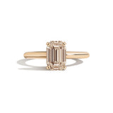 gold ring with a champagne emerald-cut diamond on a white background