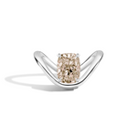 A silver ring featuring a large cushion-cut diamond with a champagne beige center, set on a sleek curved silver band against a white background.