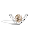 A silver ring featuring a large cushion-cut diamond with a champagne beige center, set on a sleek curved silver band against a white background.