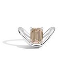 An emerald-cut diamond ring set in a polished silver-tone curved band, displayed on a clean white background with a soft shadow.
