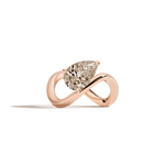 A rose gold infinity-shaped ring featuring a tilted pear champagne diamond center stone, set against a clean white background with a soft shadow.