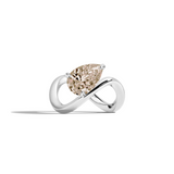 A white gold infinity-shaped ring featuring a tilted pear champagne diamond center stone, set against a clean white background with a soft shadow.