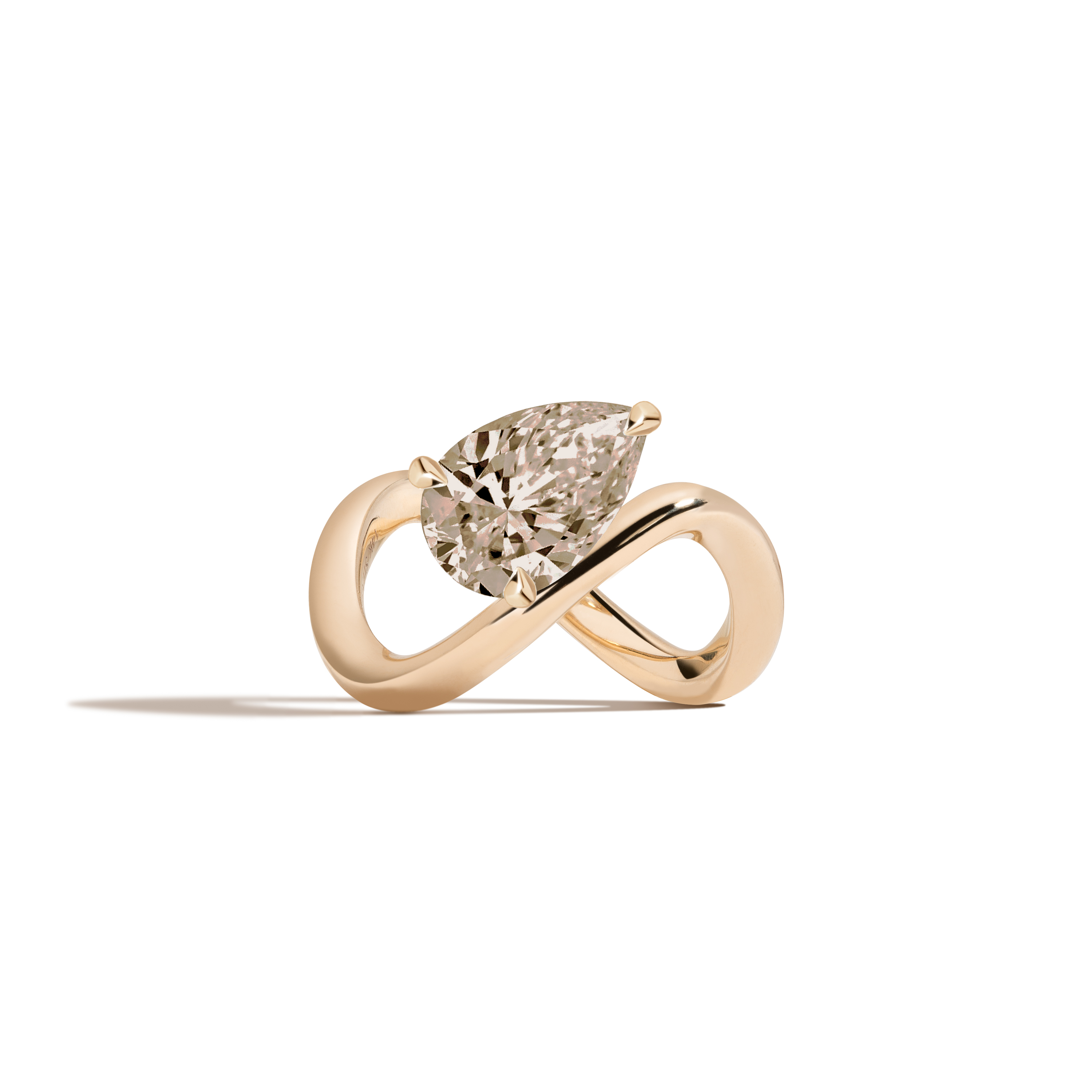 A yellow gold infinity-shaped ring featuring a tilted pear champagne diamond center stone, set against a clean white background with a soft shadow.