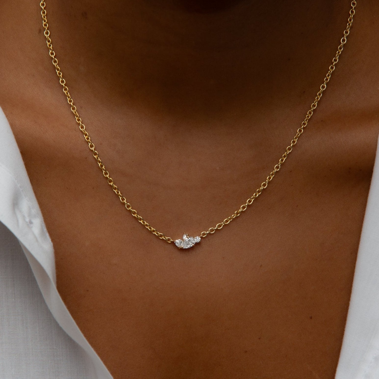 Close-up of a neck with a chain necklace with a cluster of diamonds