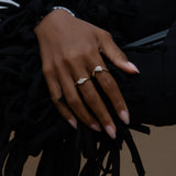 A hand wearing two yellow gold rings with diamonds
