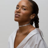 Close-up person wearing white gold diamond choker and earrings